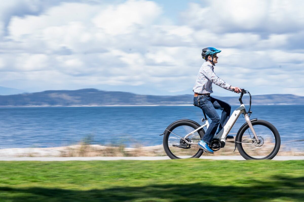 A man rides an electric bicycle along a seaside path, embracing outdoor adventure.